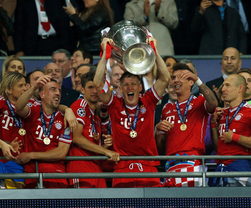 Bayern Munich's Bastian Schweinsteiger (C) holds up the trophy as he celebrates with teammates after defeating Borussia Dortmund in their Champions League Final soccer match at Wembley Stadium in London May 25, 2013. Bayern Munich overcame the heartbreak of losing two Champions League finals in three seasons by beating Borussia Dortmund 2-1 in a memorable all-German clash on Saturday to become European champions for the fifth time. REUTERS