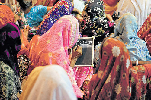 Widows practise writing at a class by an NGO in Varanasi. AP