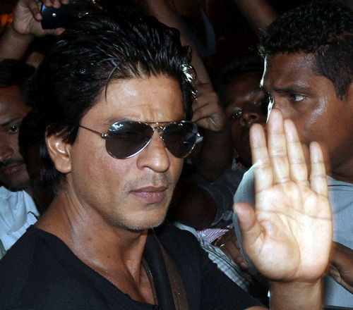 Shahrukh Khan waves to his fans after being discharged from the Lilavati hospital after shoulder operation, in Mumbai on Wednesday. PTI Photo