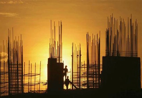 Labourers are silhouetted against the setting sun as they work at the construction site of a residential building in Hyderabad October 5, 2012. Credit: Reuters