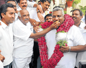 Jubilant: Mysore MP Vishwanath offers sweet to K Venkatesh, the Congress candidate, who emerged victorious in the Assembly polls from Periyapatna on Friday. dh photo