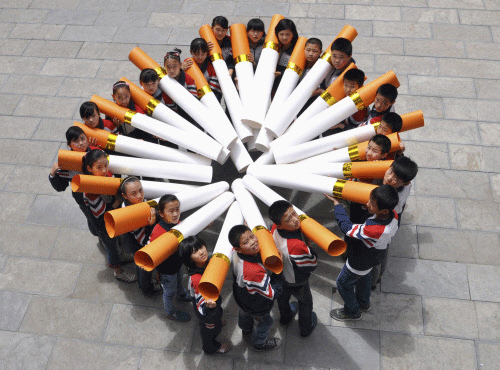 Students pose for pictures with 'big cigarette models' during campaign ahead of World No Tobacco Day, at primary school in Handan. Reuters