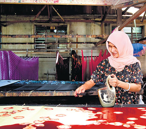 Experimental: An Indonesian woman fills in colour on 'batik' motifs