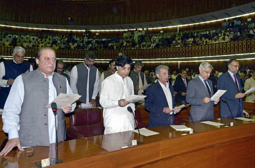 Incoming Prime Minister and Head of Pakistan Muslim League-N party Nawaz Sharif, left, takes the oath of office with other newly elected parliamentarians during the first session of the National Assembly in Islamabad, Pakistan, Saturday, June 1, 2013. Newly elected members of Pakistan's National Assembly were sworn in Saturday, officially marking the first transition of power between democratically elected civilian governments in the nearly 66-year history of this coup-prone country. (AP Photo)