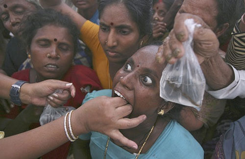 A woman prepares to swallow a live fish that has been dipped in homemade medicine during a camp in the southern Indian city of Hyderabad. Reuters