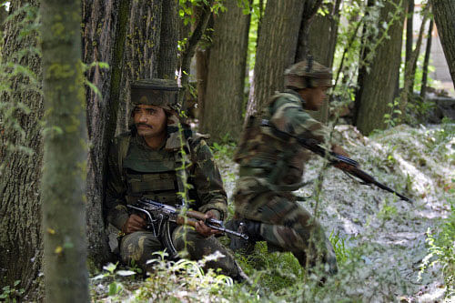 Army soldiers take position during a gunbattle in Buchoo Balla, about 40 kilometers (25 miles) south of Srinagar, India, Friday, May 24, 2013. AP photo