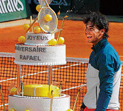 celebration time: French Open defending champion Rafael Nadal is delighted after being presented with a birthday cake following his win over Kei Nishikori on Monday. reuters