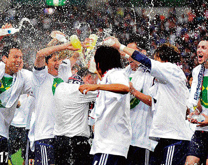 super samurais Japanese players spray water on their coach Alberto Zaccheroni (centre) after becoming the first team to qualify for the 2014 Brazil World Cup on&#8200;Tuesday. afp