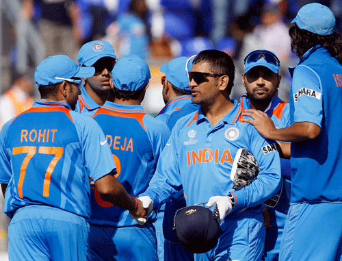 India's captain MS Dhoni, centre, reacts with teammates, as Australia are bowled out for 65 during a warm up cricket match for the upcoming ICC Champions Trophy between India and Australia at the Cardiff Wales Stadium in Cardiff, Wales, Tuesday, June 4, 2013. (AP Photo