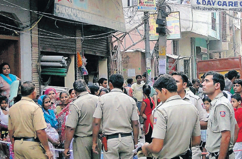 Policemen outside a house where Sarita with her two children were found dead, in Mandawali, East Delhi, on Wednesday. PTI