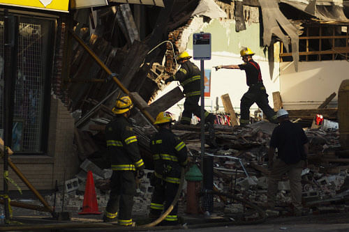 Firefighters search through rubble following a building collapse in Philadelphia June 5, 2013. A building collapsed in downtown Philadelphia on Wednesday, killing a 35-year-old woman and injuring 13 other people under mountains of crushed concrete and splintered wood, officials said. REUTERS