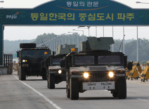 U.S. military vehicles cross Unification Bridge, which leads to the demilitarized zone, separating North Korea from South Korea in Paju, South Korea, Thursday, June 6, 2013. North and South Korea have agreed Thursday to hold talks on reopening a jointly run factory complex and possibly other issues, a hopeful sign for ending deteriorating relations that comes just as China and the U.S. prepare for a summit where the North is expected to be a key topic. The sign reads ' Unification Gate.' (AP Photo