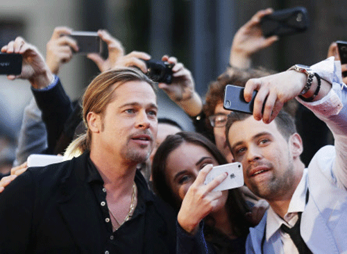 Cast member Pitt poses for pictures with fans on the red carpet of the movie premiere of 'World War Z' in Sydney Reuters Image