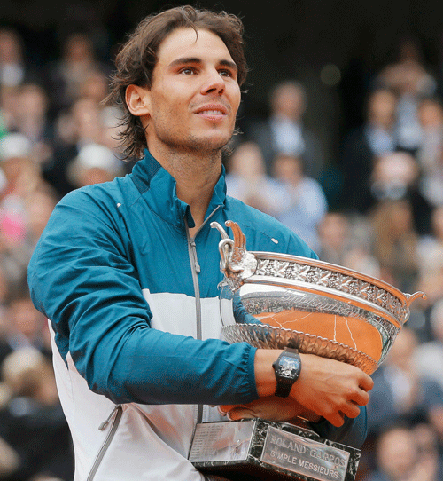 Rafael Nadal of Spain hugs his trophy after defeating compatriot David Ferrer in their men's singles final match to win the French Open tennis tournament at the Roland Garros stadium in Paris June 9, 2013. Nadal made light work of fellow Spaniard Ferrer to win a protest-interrupted French Open final 6-3 6-2 6-3 on Sunday and become the first man to win eight singles titles at the same tournament. REUTERS