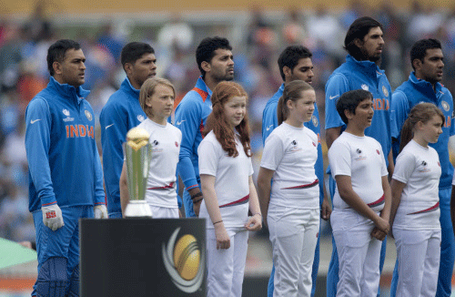 Members of the India team listen to their national anthem as they stand with young mascots before the ICC Champions Trophy group B cricket match between India and West Indies at The Oval cricket ground in London, Tuesday, June 11, 2013. Ap Photo