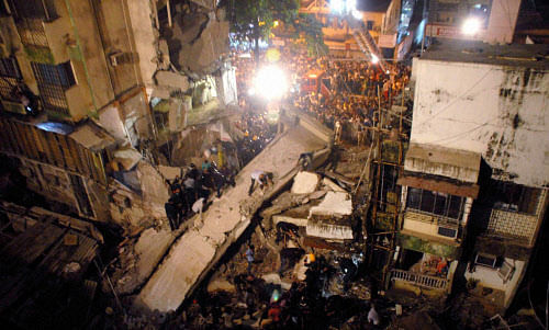 Rescuers search for survivors among the debris of a portion of a building which collapsed in Mahim in central Mumbai on Monday. Several people are feared trapped under the debris PTI Photo