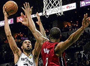 In control: Tim Duncan (left) of San Antonio Spurs tries to shoot past Chris Bosh of Miami Heat on Tuesday. AFP