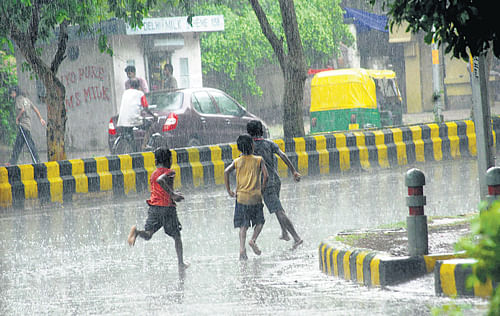 Children enjoy rain in New Delhi on Friday. DH photo