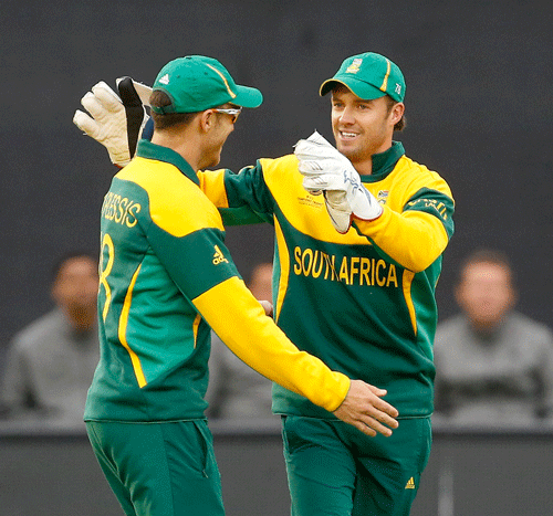 South Africa's AB de Villiers, right, celebrates with Faf du Plessis after he catches out West Indies' Johnson Charles during an ICC Champions Trophy cricket match between West Indies and South Africa at the Cardiff Wales Stadium in Cardiff, Friday, June 14, 2013. (AP Photo
