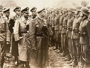 The June 3, 1944 photo provided by the US Holocaust Memorial Museum shows Heinrich Himmler, centre, SS Reichsfuehrer-SS, head of the Gestapo and the Waffen-SS, and Minister of the Interior of Nazi Germany from 1943 to 1945, as he reviews troops of the Galician SS-Volunteer Infantry Division Michael Karkoc a top commander whose Nazi SS-led unit is blamed for burning villages filled with women and children lied to American immigration officials to get into the United States and has been living in Minnesota since shortly after World War II, according to evidence uncovered by The Associated Press. Michael Karkoc became a member of the Galician division after the Ukrainian Self Defense Legion was incorporated into it near the end of the war. AP photo