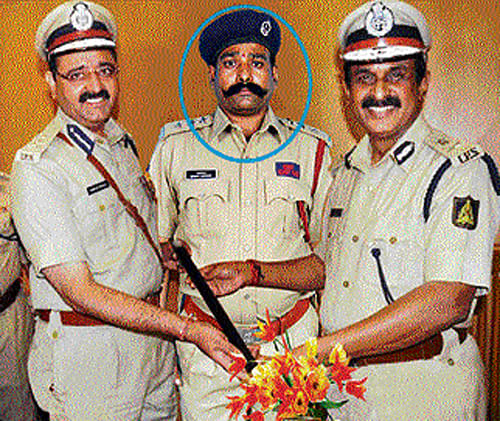 Rajaram (circled), in this doctored photograph, has inserted his image with police officers Raghavendra Auradkar and Jyotiprakash Mirji to con people.