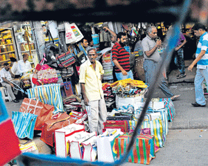 NEEDING&#8200;ATTENTION: A vendor waits for customers at his roadside stall selling bags in the old quarters of Delhi. The RBI says it will increasingly monitor prices at a retail level, partly because the wide gap has made the consumer index difficult to ignore. The bank is expected to one day make the consumer index its main gauge, like most other countries. Reuters