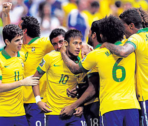 Brazil's Neymar (centre) celebrates with his team-mates after scoring the opening goal against Japan. reuters
