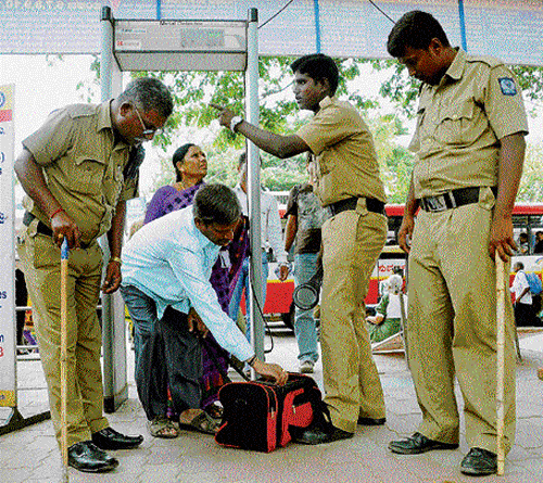 high alert: Police check the luggage of passengers at the Kempegowda bus terminal in  Bangalore on Sunday. dh photo