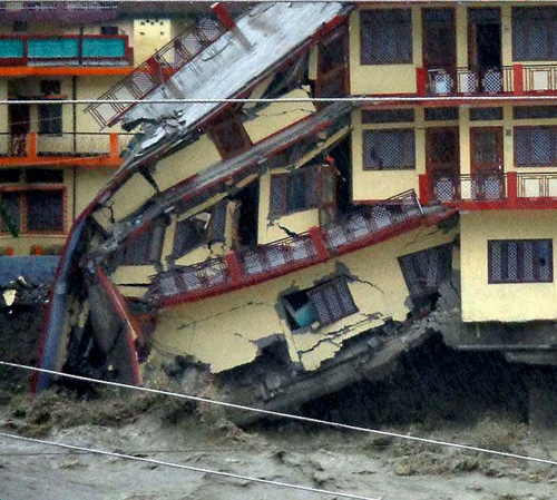 A three-story building is destroyed by floodwaters, in Uttarkash, in northern Indian state of Uttarakhund. Government officials say at least 23 people have died and about 50 are missing after three days of torrential rain washed away buildings and roads in northern India. (AP Photo