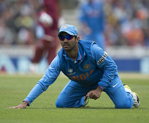 Dinesh Karthik gets back up after diving to field the ball during the ICC Champions Trophy group B cricket match between India and West Indies at The Oval cricket ground in London, Tuesday, June 11, 2013. AP Photo