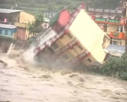 A building collapses into the rising water of river Ganga in northern India's pilgrimage town of Uttarkashi in this still image taken from video June 16, 2013, after 36 hours of rain. REUTERS