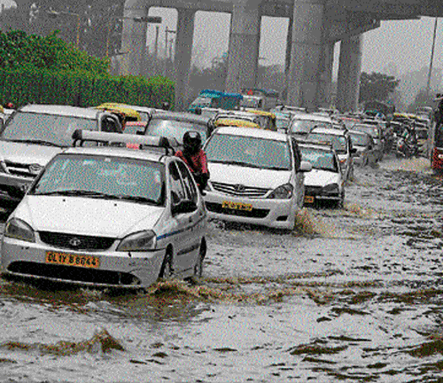 People had a hard time commuting as roads were waterlogged following heavy rain on Monday. Some vehicles were stuck in water while trees were uprooted in some areas. PTI photos
