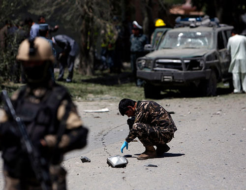 Afghan security forces personnel investigate the site of an explosion in Kabul June 18, 2013. A bomb targeted a senior Shia Muslim cleric in the west of Kabul on Tuesday, police said, shortly before the international military coalition marked its final handover of security to national forces. REUTERS