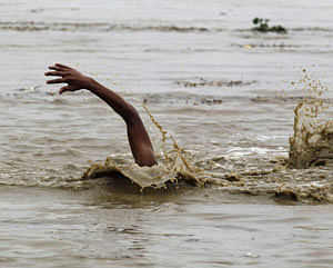 A man swims in the flooded waters of river Yamuna to retrieve floating watermelons in New Delhi June 18, 2013. The rains are at least twice as heavy as usual in northwest and central India as the June-September monsoon spreads north, covering the whole country a month faster than normal. REUTERS