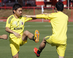 Japan's Shinji Kagawa, right, and Yuto Nagatomo, left, stretch during a training session of Japan national team at the soccer Confederations Cup in Brasilia, Brazil, Monday, June 17, 2013. AP Photo