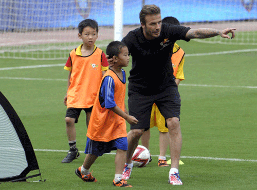 Soccer star David Beckham instructs Chinese children during an appearance at a stadium in Nanjing in eastern China's Jiangsu province Tuesday June 18, 2013. Beckham is on a seven-day tour in China as a soccer ambassador for the China Super League. (AP Photo)