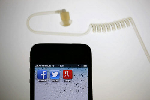 The application icons of Facebook, Twitter and Google are displayed on an iPhone next to an earphone set in this illustration photo taken in Berlin, June 17, 2013. European firms believe revelations that the U.S. National Security Agency (NSA) PRISM programme secretly gathered user data from nine big U.S. Internet companies, including Microsoft and Google, will hand them a competitive advantage as they play catch-up with the dominant American players in 'cloud computing'. REUTERS