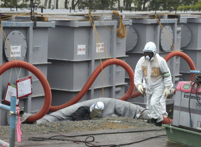 A worker walks in front of water tanks at Tokyo Electric Power Company's (TEPCO) tsunami-crippled Fukushima Daiichi nuclear power plant in Fukushima prefecture in this June 12, 2013 file photo. High levels of a toxic substance called strontium-90 have been found in groundwater at the devastated Fukushima nuclear power plant in Japan, the utility that operates the facility said on Wednesday. Testing of groundwater outside the turbine building of reactor No. 2 had shown the level of strontium-90 had increased by more than 100 times between December 2012 and May this year, Toshihiko Fukuda, a general manager at TEPCO, told a news conference. REUTERS