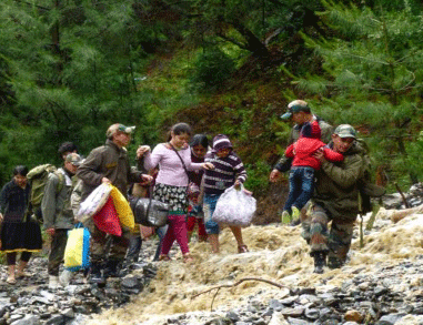 Indian army, Indian army soldiers help stranded people to reach at safer place in Uttarkashi, in northern Indian state of Uttrakhund. India's army and air force evacuated nearly 12,000 Hindu pilgrims stranded in a mountainous area after torrential monsoon rains and landslides caused death and destruction in northern India.