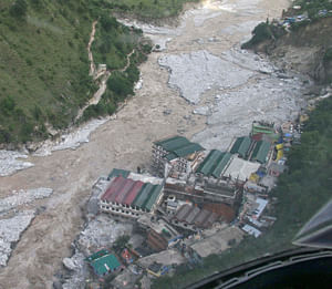 Flood waters flow next to a residential complex after heavy rains in the Himalayan state of Uttarakhand June 19, 2013. India's monsoon rains could ease soon after hitting 89 percent over averages in the week to June 19, according to weather office sources, in a third straight week of downpours that have caused major flooding in north India. Picture taken June 19, 2013. REUTERS