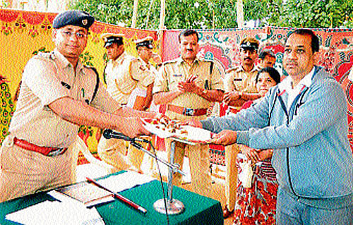 Superintendent of Police Amit Singh returns the valuables to the respective owners in Hassan on Thursday. dh photo