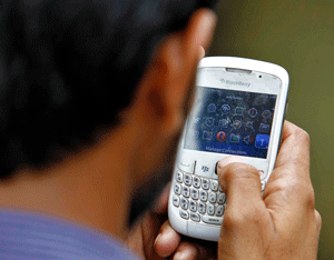 A man checks his mobile phone near a marketplace in New Delhi June 18, 2013. India has launched a wide-ranging surveillance programme that will give its security agencies and even income tax officials the ability to tap directly into e-mails and phone calls without oversight by courts or parliament, several sources said. Picture taken June 18. REUTERS