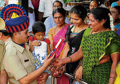 Pride possession: A policeman shows the medal he won to his family at an investiture ceremony held in Bangalore on Thursday. dh photo