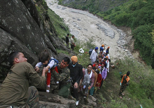 Soldiers rescue stranded people after heavy rains in the Himalayan state of Uttarakhand June 18, 2013. India's monsoon rains could ease soon after hitting 89 percent over averages in the week to June 19, according to weather office sources, in a third straight week of downpours that have caused major flooding in north India. Picture taken June 18, 2013. REUTERS