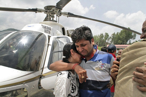 A flood hit couple console one another after being evacuated by helicopter from the upper reaches of Uttrakhand, in Dehradun, India, Thursday, June 20, 2013. Days after floods killed more than 100 people - possibly many more - rescuers used helicopters and climbed through mountain paths to reach nearly 4,000 people trapped by landslides in a narrow valley near a Hindu shrine in the northern Himalayas, officials said Thursday. (AP Photo)