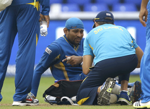 Sri Lanka's Tilakaratne Dilshan is treated for an injury during the ICC Champions Trophy semifinal between India and Sri Lanka at the Cardiff Wales Stadium, in Cardiff, Thursday, June 20, 2013. AP Photo.