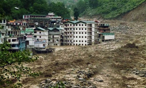 Houses are partly submerged in the flooded Alaknanda River in Govind Ghat, in Uttarakhand. PTI Photo.
