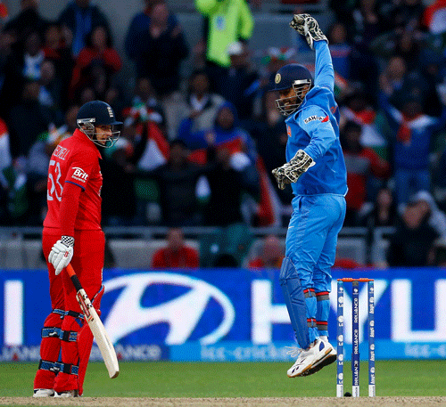 India's Mahendra Singh Dhoni (R) celebrates victory as England's James Tredwell watches during their ICC Champions Trophy final match at Edgbaston cricket ground in Birmingham, central England, June 23, 2013. REUTERS
