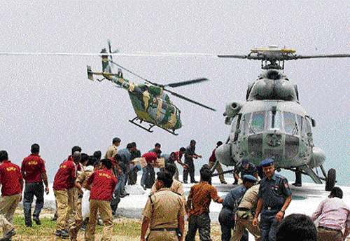 Armed personnel carry relief supplies from a helicopter for stranded people at Guptkashi on Sunday. REUTERS