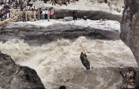 ITBP personnel rescuing a woman pilgrim with the help of a ropeway constructed above Alaknanda river at Lambagar in Uttarakhand on Monday. PTI Photo